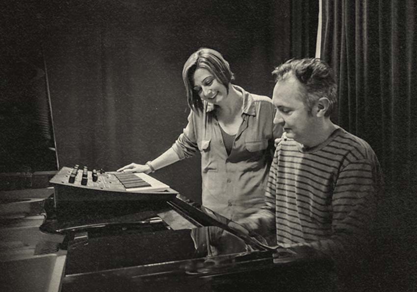 A man and a woman in front of a piano